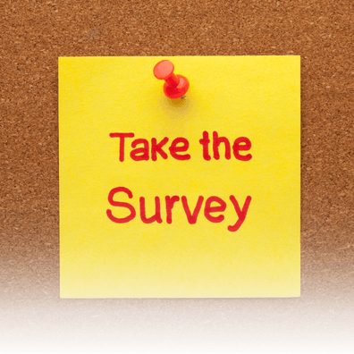 Brown corkboard with a yellow sticky note. 