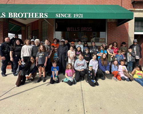 Officers and kids posing for a group photo. 
